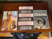 Vogue magazine, People Diana special, three sealed stamp booklets on table