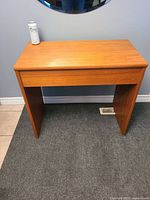 Front view of teak vanity desk, closed top