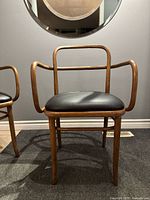 Front view of Thonet bentwood armchair with black upholstered seat