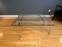 Full view of square glass coffee table, chrome legs visible