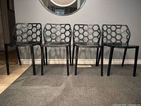 Front view of four smoked Lucite honeycomb chairs
