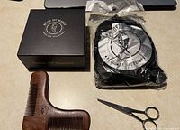 Box, comb, scissors, sealed pouch with bib