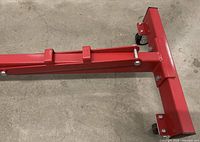 Top view of red steel engine stand base showing T configuration and casters