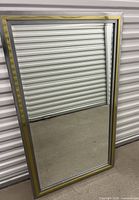 full view of rectangular chrome and gold framed mirror
