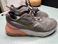 Left side view showing grey upper, coral heel, gold swoosh
