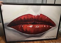 Full view of framed wall art showing red lips image and signature