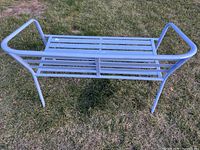 front view of purple metal slat bench on grass