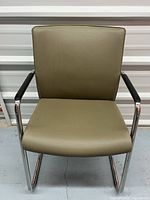 Front view of tan cantilever chair with chrome frame
