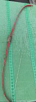 Full view of red fiberglass recurve bow showing shape and string