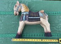 Full left-side view of carved wooden horse with measuring tape showing height