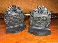 Front view of both bronze bookends showing relief decoration and inscriptions
