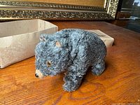 Side view of plush bear toy on wooden surface