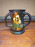 Front view of twin-handled Roseville Rozane vase showing floral decoration