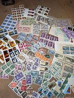 Overview of assorted Canadian and U.S. stamps scattered on surface
