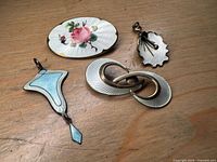 Front view showing all four enamel jewellery pieces