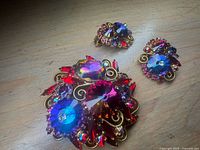Front view of brooch and earrings showing rhinestone colours and design