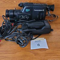 Full view of camcorder with charger and cables on table