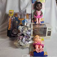 Group shot of all items including Thanos figure, Baby Alive doll, Funko set, clown doll, small baby doll