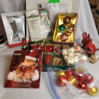 Group shot showing all items: catalog, craft kit, ornaments, tree topper, figurines, cardinal centerpiece