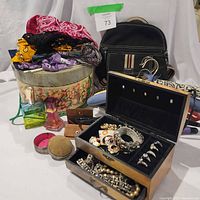 Group shot of all items including purse, bandanas, jewelry box, perfume bottles, compact, curling irons