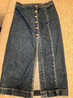 Front view of Free People denim maxi skirt showing button closure and slit