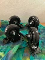 Four black swivel plate casters grouped together