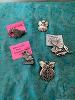 Group shot of all five brooches laid out on fabric