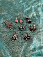 All seven pairs of sterling silver earrings on fabric background