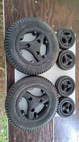 All wheels laid out on table: two large 3.00-8 drive wheels and four smaller caster wheels