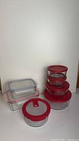 Full set showing stacked round containers with red lids and stacked rectangular containers with clear lids