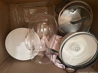 Box containing casserole dish, stainless saucepan with lid, rectangular glass baker, cylindrical glass vessel, separate lids
