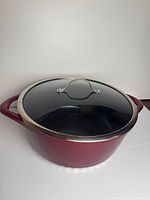 Skillet with lid in place, showing red exterior and glass lid