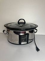 Complete slow cooker assembled with lid and power cord visible