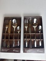 Front view of both sealed Fontignac 4-piece flatware boxes