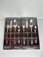 Front view showing two identical boxed 4-piece Fontignac flatware sets