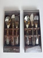 Front view of both sealed Fontignac cutlery boxes showing spoon, knife, fork with animal-motif handles