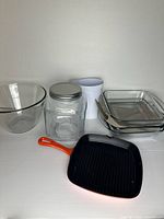 All eight items grouped: grill pan, two baking dishes, mixing bowl, jar, pitcher, two liners