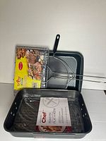 Group shot showing all items: Master Chef roaster with rack in packaging, grill basket, wire rack, two enamel pans