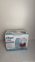 Front view of boxed Oster Perfect Pastels 3-cup chopper
