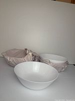 Three of the white ceramic bowls, two wrapped, showing size and shape