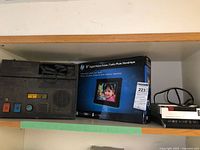 Overview of all three items on shelf: Language Master, HP photo frame box, Superscope recorder