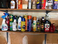 Overview of two shelves with assorted cleaners, lubricants and pest control products