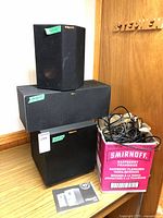 RP-240S surround speaker on top of center speaker, subwoofer below, box of cables at right