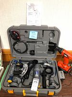 Overall view showing spin saw kit open in case and Black & Decker drill beside it