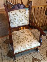 front view showing carved crest rail, upholstery pattern and rocker base