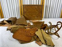Overall lot with hide, tooled panels, scraps and straps visible