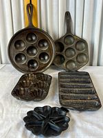 All five cast iron bakeware pieces displayed