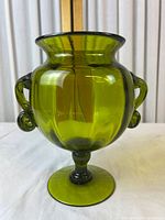 Front view showing ruffled rim, scroll handles, pedestal foot, olive green color