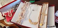 Overall view of open boxes showing multiple pearl necklaces and bracelets