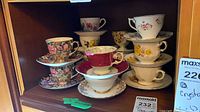Shelf showing all six teacup and saucer sets in cabinet